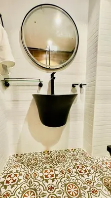 a bathroom with a black tub and a round mirror at Luxurious place to stay in Dubai Marina in Dubai