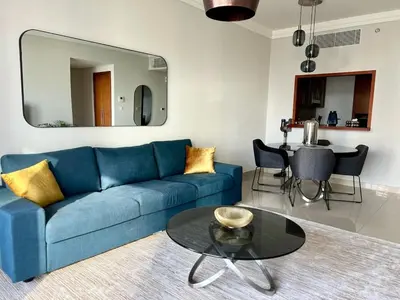 a living room with a blue couch and a table at Elegant apartment Dubai downtown in Dubai