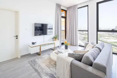 a living room with a couch and a tv at Frank Porter - Noor 3 Midtown in Dubai