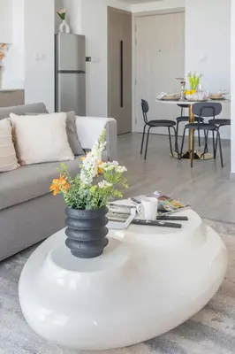 a living room with a white coffee table with flowers on it at Frank Porter - Noor 3 Midtown in Dubai