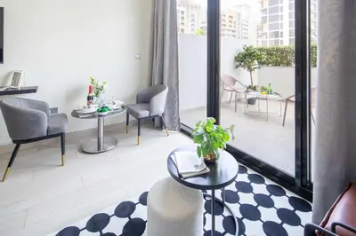 a living room with tables and chairs and a large window at Frank Porter - Azizi Riviera 36 in Dubai