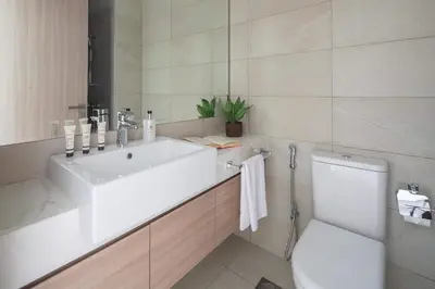 a white bathroom with a sink and a toilet at Frank Porter - Azizi Riviera 36 in Dubai