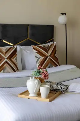 a tray with two cups and flowers on a bed at Frank Porter - Azizi Riviera 36 in Dubai
