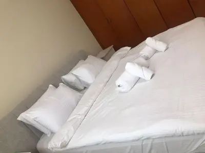 a white bed with pillows and towels on it at Cozy Bedroom Retreat in Green Community Pool View in Dubai