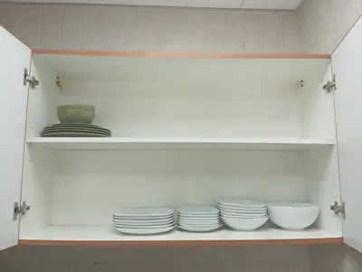 a shelf with plates and bowls in a kitchen at Cozy Bedroom Retreat in Green Community Pool View in Dubai