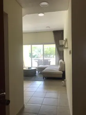 a living room with a couch and a chair at Cozy Bedroom Retreat in Green Community Pool View in Dubai