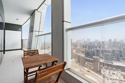 a balcony with a wooden bench and a view of the city at ALiving Luxury 3BR High-Rise I Burj Khalifa View I Paramount Towers, 6101 in Dubai