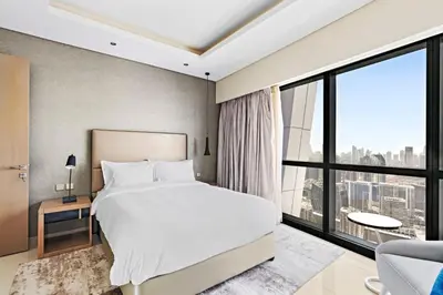 a bedroom with a large bed and a large window at ALiving Luxury 3BR High-Rise I Burj Khalifa View I Paramount Towers, 6101 in Dubai