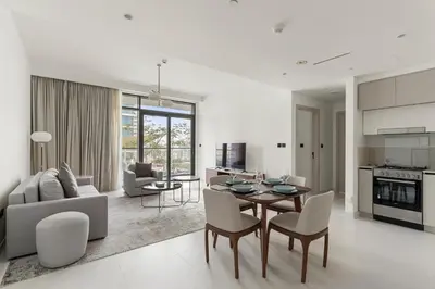 a kitchen and living room with a table and chairs at Luxury Stay at Marina Vista, Dubai Harbour in Dubai