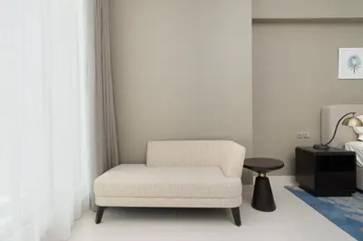 a white chair in a room with a lamp at BellaViu Holiday Homes-From City Rush to Calm -2BR Retreat in DAMAC Prive in Dubai