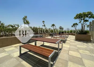 a row of benches sitting next to a sign at Bloomfields 1br Azizi Farhad Burj View Bliss in Dubai