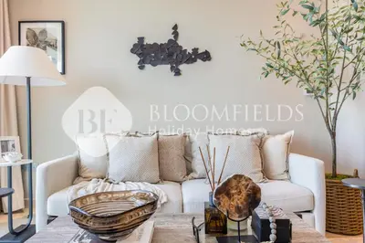 a living room with a white couch and a table at Bloomfields 1br Azizi Farhad Burj View Bliss in Dubai