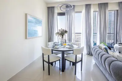 a dining room with a table and chairs and a couch at Frank Porter - Harbour Views T1 in Dubai