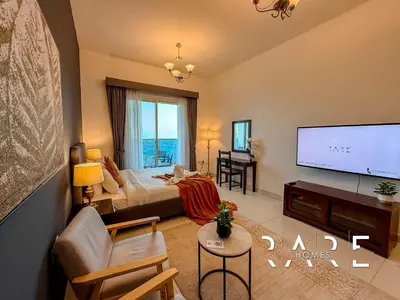 a hotel room with a bed and a tv at Rare Holiday Homes - Near Miracle Garden - Dubai Sports City - Elite Residence - R1108 in Dubai