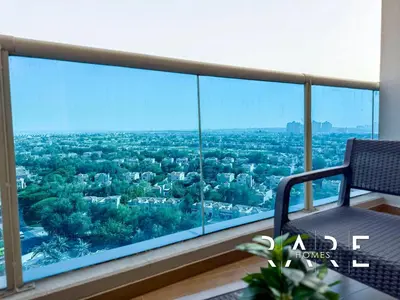 a room with a view of the city from a balcony at Rare Holiday Homes - Near Miracle Garden - Dubai Sports City - Elite Residence - R1108 in Dubai