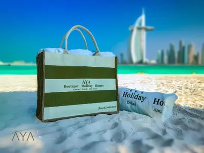 a shopping bag sitting on the sand on the beach at Beachfront Bliss - Marina View - JBR The Address By ĀYA Boutique in Dubai