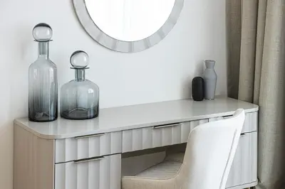 a dressing table with two glass bottles and a mirror at Beachfront Bliss - Marina View - JBR The Address By ĀYA Boutique in Dubai