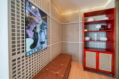 a room with a bench and a tv on a wall at PVH - 2BR Artistic Retreat in Downtown Views 2 in Dubai
