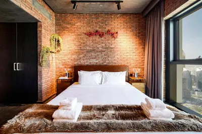 a bedroom with a large bed and a brick wall at PVH - Edgy and Modern Comfort 1BR Downtown Views 2 in Dubai