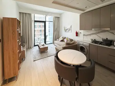 a kitchen and living room with a table and a stove at Azizi Riviera15 - Meydan by Golden Casa in Dubai