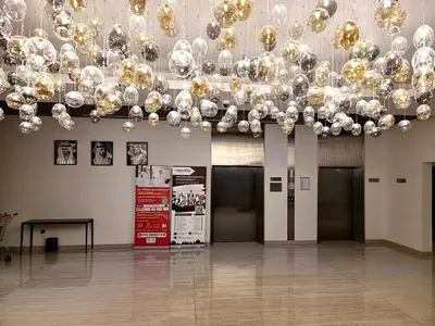 a room with a bunch of balloons hanging from a ceiling at Azizi Riviera15 - Meydan by Golden Casa in Dubai