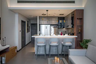 a kitchen with a bar with stools in it at High Floor With Marina View in Dubai