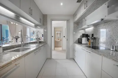 a kitchen with white cabinets and a sink at EasyGo-Signature, City Center, City view in Dubai