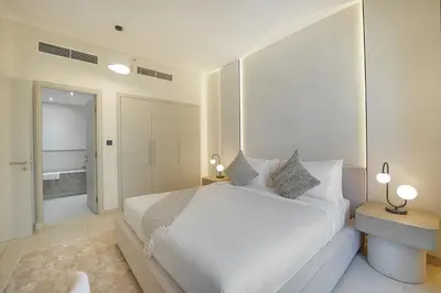 a white bedroom with a large bed and a bathroom at EasyGo-Signature, City Center, City view in Dubai