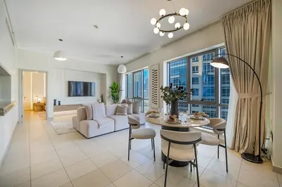 a living room with a table and chairs and a couch at EasyGo-Signature, City Center, City view in Dubai