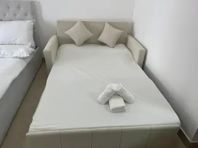 a white bed with a teddy bear on it at Nice Studio On Marina Walk in Dubai
