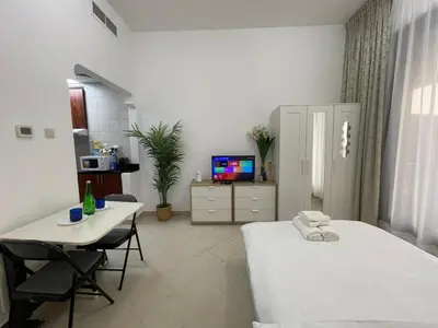 a room with two beds and a table and a tv at Nice Studio On Marina Walk in Dubai