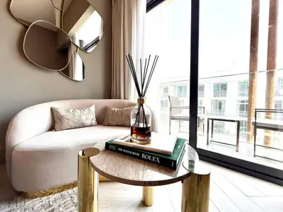 a living room with a couch and a table at Elegant and Cozy Studio Apartment - Amenities Access in Dubai