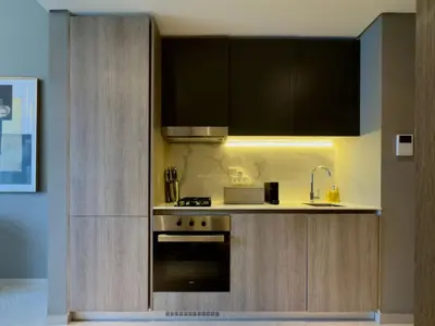 a kitchen with a sink and a stove and cabinets at Elegant and Cozy Studio Apartment - Amenities Access in Dubai