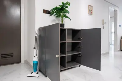 a black cabinet with a potted plant on top of it at Luxury JLT 1BR Lakeview 5 min Metro & Marina in Dubai