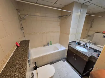 a bathroom with a tub and a toilet and a sink at Dubai Marina Amazing 1BR with Promenade view and Pool view --- Next to JBR beach---Opp JBR tram station in Dubai