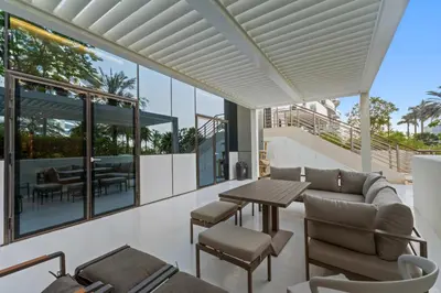 a living room with a couch and a table and chairs at Resort Style 2BR Pool Access Private Beach in Dubai