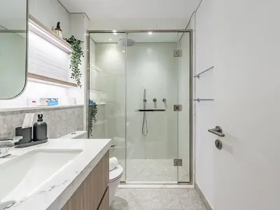 a bathroom with a shower and a sink and a toilet at Modern & Luxury 1BR -Pool View - Kensington Waters in Dubai