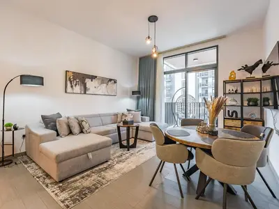 a living room with a couch and a table at Modern & Luxury 1BR -Pool View - Kensington Waters in Dubai
