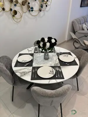 a white table with chairs and a vase of flowers at 1 BR Apartment in Downtown Dubai in Dubai
