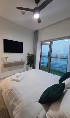 a bedroom with a large white bed with a large window at 1 BR Apartment in Downtown Dubai in Dubai