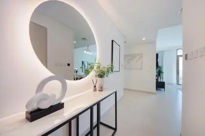 a hallway with a large mirror and a table with flowers at Brand new and stylish 2BR with stunning views - Creek Palace in Dubai
