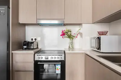 a kitchen with a stove and a microwave at Burj Khalifa View 2 BR Apartment w Parking in Dubai