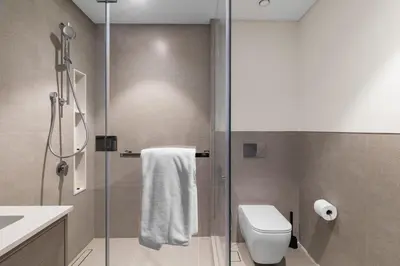 a bathroom with a shower and a toilet and a sink at Burj Khalifa View 2 BR Apartment w Parking in Dubai