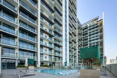 an apartment building with a swimming pool and a building at Community Views 1BR Next to Mall and Park, Binghatti Amber, Jumeirah Village Circle by Deluxe Holiday Homes in Dubai