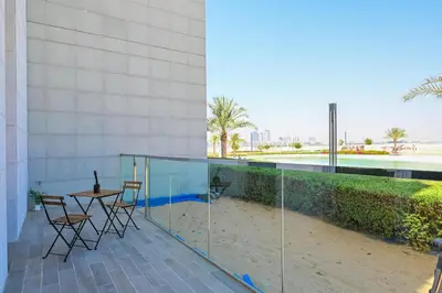 a balcony with a table and chairs on a building at Crystal Escape 1BR Lagoon Access in Dubai