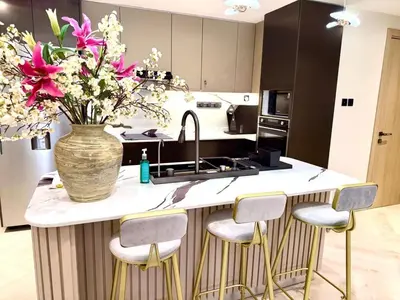 a kitchen with a vase of flowers on a counter at Cozy, Fully Fitted Smart Home in Dubai