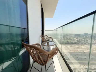 a balcony with two chairs and a table on a building at Relax In Style 1br Haven In Binghatti Venus! in Dubai