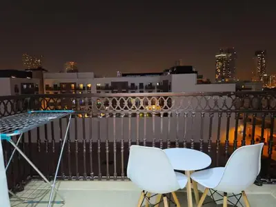 two chairs and a table on a balcony at night at ARS vacation homes rental in Dubai