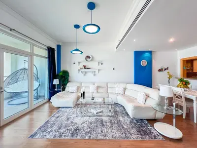 a living room with a white couch and a table at 1 BHK Palm Jumeirah Sea View Al Sultana Shoreline in Dubai