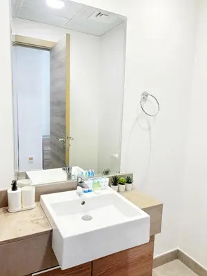a bathroom with a white sink and a mirror at Modern Fully Furnished Apartment in Bloom Tower B JVC - Easy Access to JBR, Circle Mall & Dubai Hills Mall in Dubai
